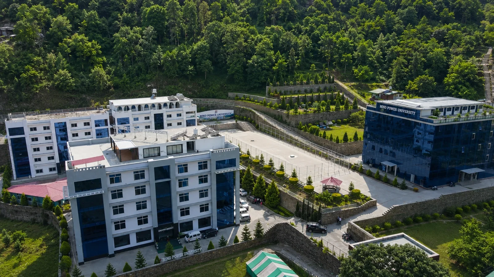 The campus from the air — the academic blocks and the terraced grounds